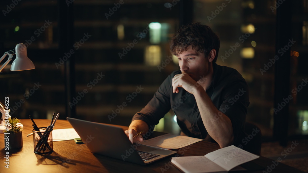 Obraz premium Depressed worker looking laptop at night company workspace closeup. Tired man