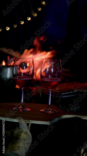 Romantic fireplace with wine glasses and burning firewood