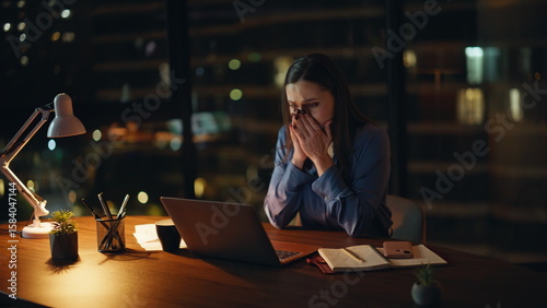 Desperate manager reading dismissal notice at night workplace. Stressed woman