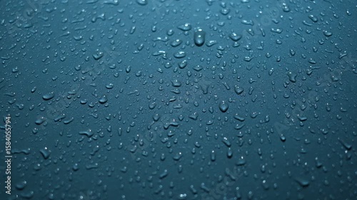 A wet surface with many drops of water on it. The water droplets are scattered all over the surface, creating a sense of movement and fluidity