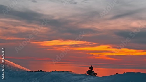 Sunset hiker snowy mountain peak.