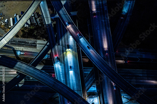 Close-Up Aerial View of Los Angeles Highway at Night with Vibrant Headlights and Intersecting Ramps