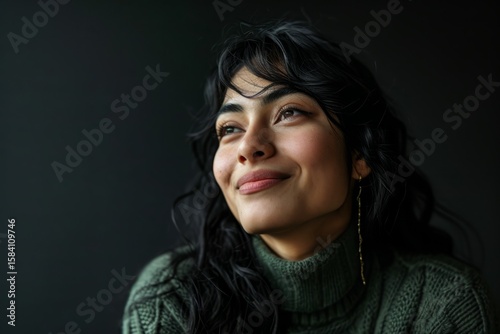 Portrait of a beautiful woman in a green sweater on a dark background
