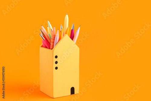 Colorful pens in yellow hou...