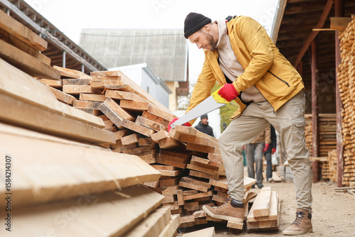 Male carpenter sawing woode...