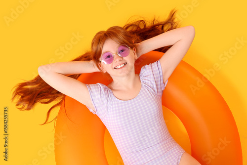 Little redhead girl lying o...