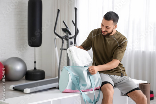 Young man taking towel from...