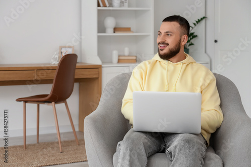 Handsome man using laptop i...
