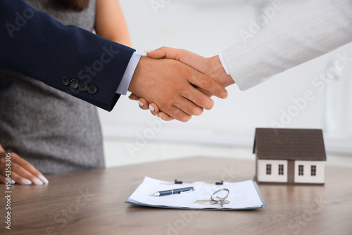 Young couple shaking hands ...