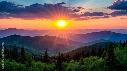 Dramatic mountain sunrise over forest valley with vibrant colors in sky and clouds