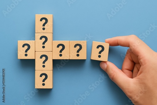 Creative Concept of Uncertainty and Questions with Wooden Blocks on Blue Surface, Symbolizing Search for Answers and Solutions in Life