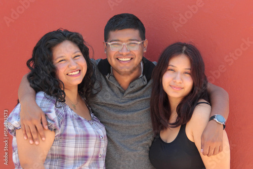 A group of young, dark-skinned Latino friends and family enjoy their time together, show their love, and celebrate their friendship