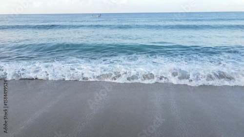 Ocean waves gently crash on pristine white sand beach shore tranquil blue water peaceful serenity summer day coastal scene nature beauty seascape calm waves tranquil atmosphere