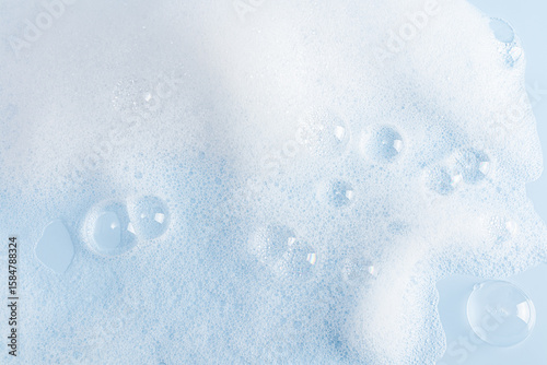 Abstract background of white soap foam texture. shampoo, shower gel with bubbles. delicate blue white cosmetic background.