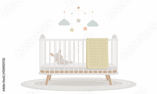 A white baby crib with a mobile, blanket, and stuffed animal on a round rug, isolated on a white background.