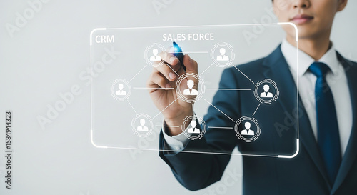 Man in suit drawing sales force crm network diagram on transparent screen with blue marker pen tool