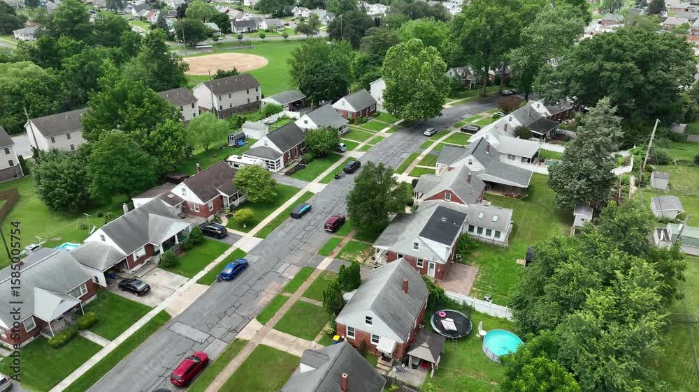 Peaceful and quaint neighborhood in suburbia of town. Sunny day in summer. Green grass in yards and garden. Houses and homes in middle class district of Pennsylvania.