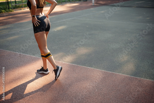 Woman Exercising with Resistance Band on Sports Court