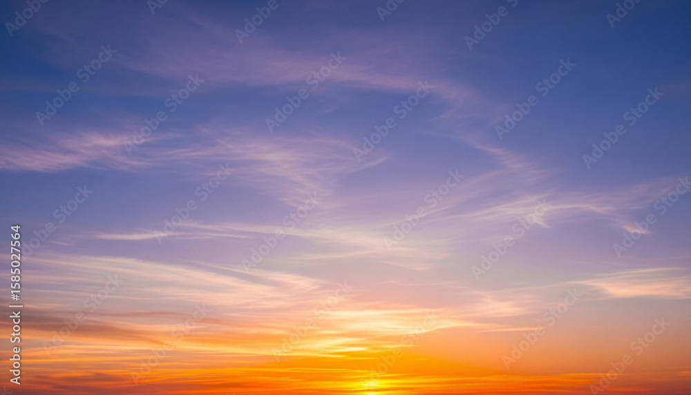 Obraz premium Colorful sunset sky with scattered clouds glowing in orange, yellow, and soft blue shades, creating a soothing natural gradient ideal for calm visual compositions or headers.