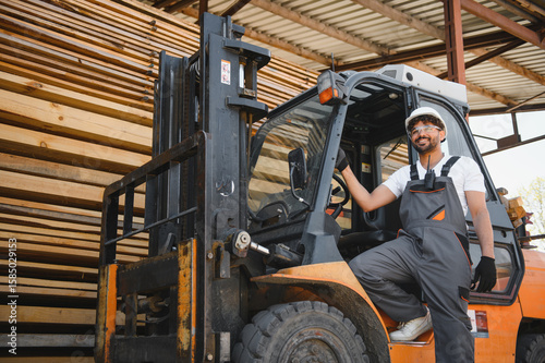 Warehouse worker driving forklift near lumber stacks