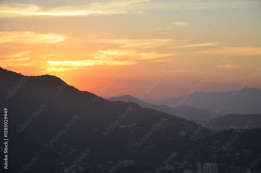 Obraz premium Sunset at night on Rio de Janeiro with city lights and the sea and the mountains