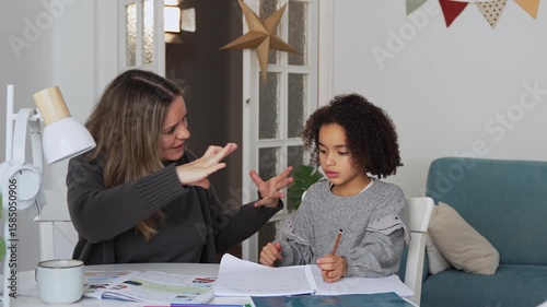 Caucasian mother and African American daughter studying at home, doing homework in cosy white room. Parent teach, child school girl learn knowledge, write exercise read book. Education for children