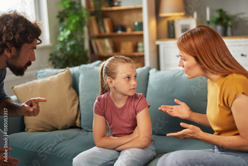 фотографія Parents communicate with their child regarding her behavior while seated in a comfortable living room, creating a serious yet constructive atmosphere for open dialogue