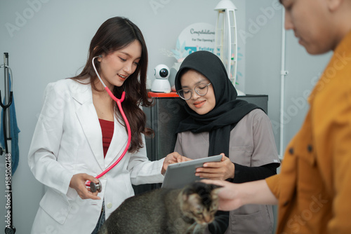 Veterinarians Discussing Pet Health with Digital Tablet in Clinic