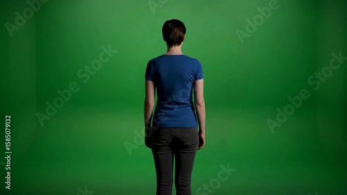 Young Person in Blue Shirt Pointing with Open Mouth Against a Bright Green Background