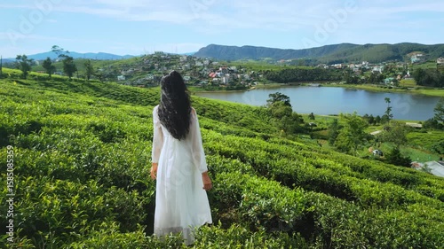 Drone Crosses Peaceful Tea Hills With Woman in White Looking at Lake