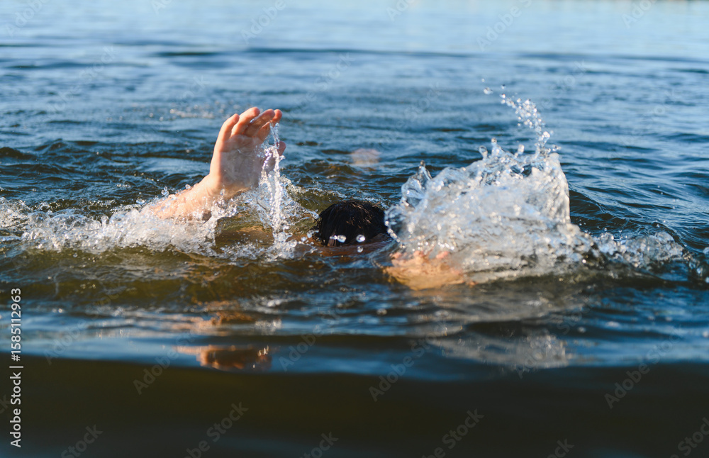 Obraz premium Man drowning in water, reaching for help in open lake