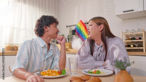 Asian transgender woman and her male partner eating breakfast in house. 