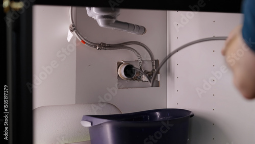 Photos Plumber drill through clogged sink pipes with spring tube tool