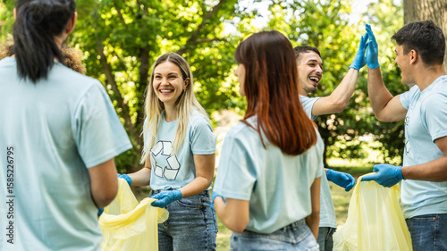 Quadro su tela Group of volunteer cleaning picking up plastic litter in the park - Diverse grou