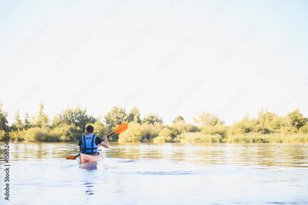 Fototapeta premium Kayaker paddling on calm lake enjoying water sports and active recreation