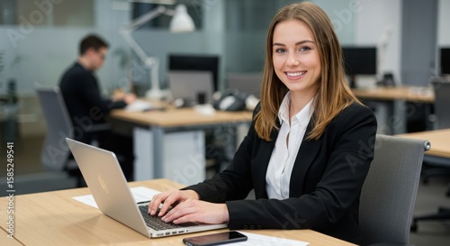 Photo of a businesswoman is working on a laptop in a modern office