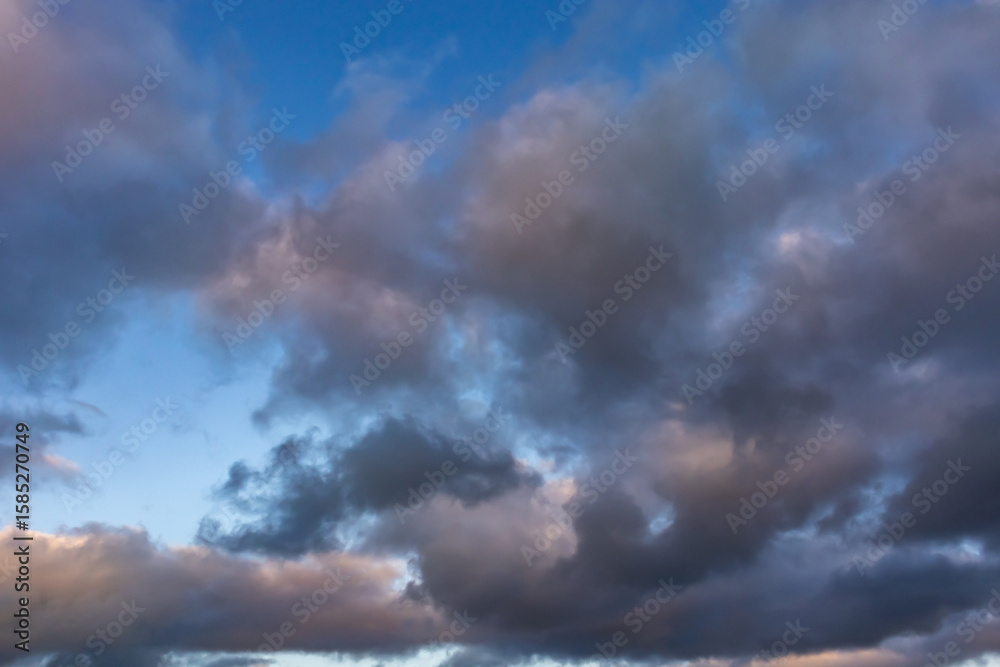 Obraz premium Colourful evening sky with dramatic clouds and patches of blue during sunset