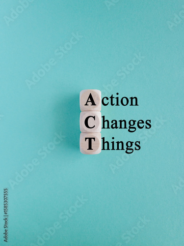 Wooden cubes with the letters A, C and T on beautiful blue background. Symbolizes the process of taking action to implement changes in various aspects of life or business.