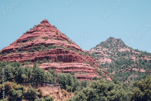 Red rock peaks rise above a forest