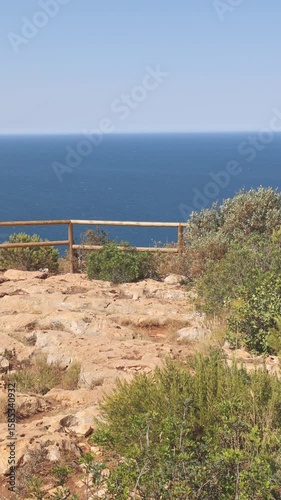Wide scenic view of the Mediterranean Sea from the cliffside viewpoint at Cape Sant Antoni in Javea, Spain, with clear blue water and sky stretching to the horizon