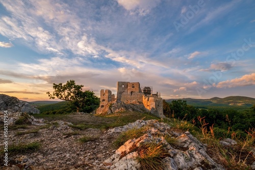Εκτύπωση καμβά Medieval building illuminated by the setting sun and blue sky with clouds