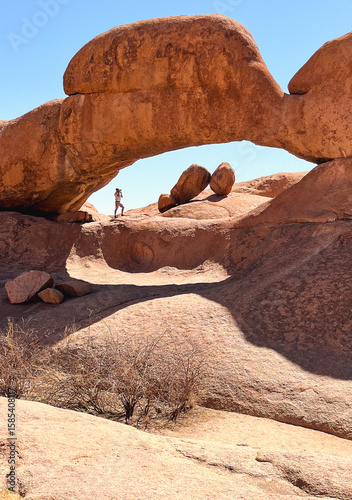 Man under a red arch in Spitzkoppe, Namibia