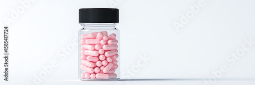 Jar of Pink Capsules: A clear jar filled with pink capsules and pills, set against a white background. Medical supplies, health aids, and treatment concepts.