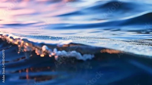 Serene blue water ripples reflecting soft light at sunset, creating a tranquil atmosphere