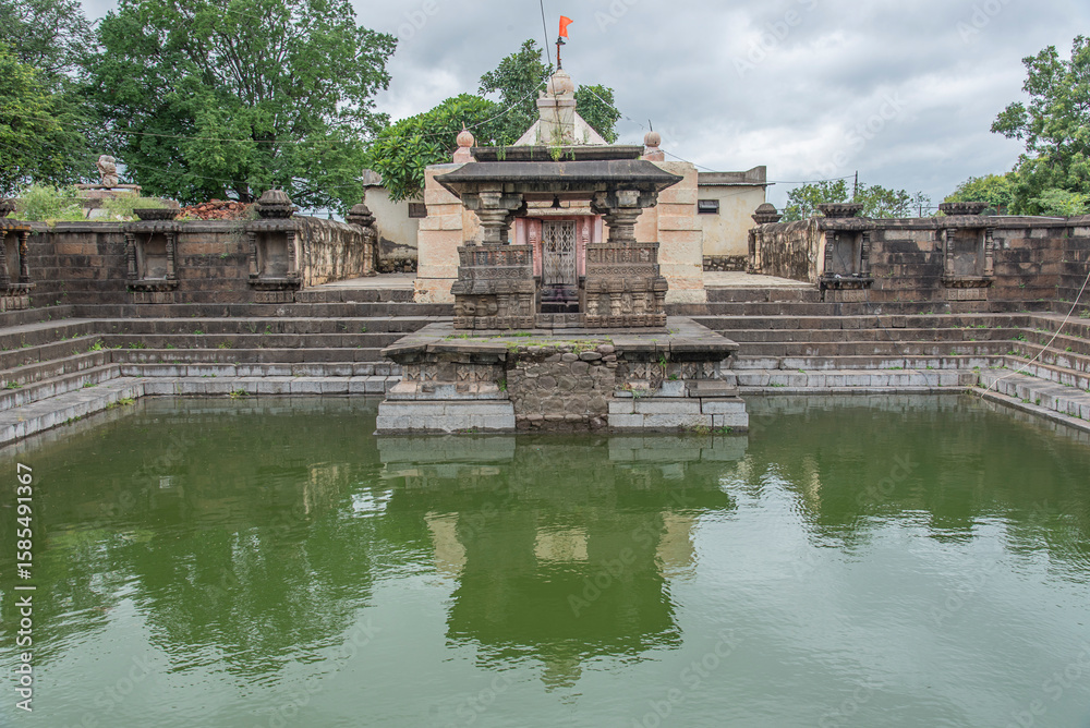 Obraz premium Elegant step-well known as Pushkarni. surrounded by a stone wall with 24 niches devkoshatas, Pushkarni is amplified by the wonderfully carved pavillion, Loni Bhapkar, Morgaon, Maharashtra, India.