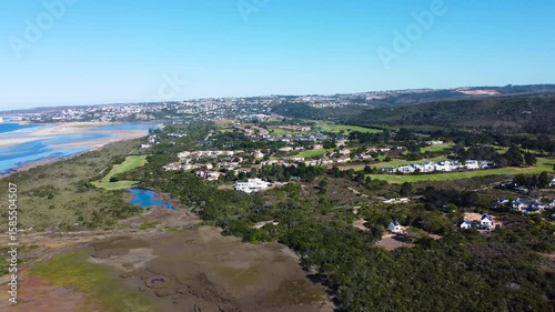 Camera moving over the neighbourhood outside the Coastal Town of Plettenberg Bay and the mouth of the Keurbooms river, 4K aerial video.