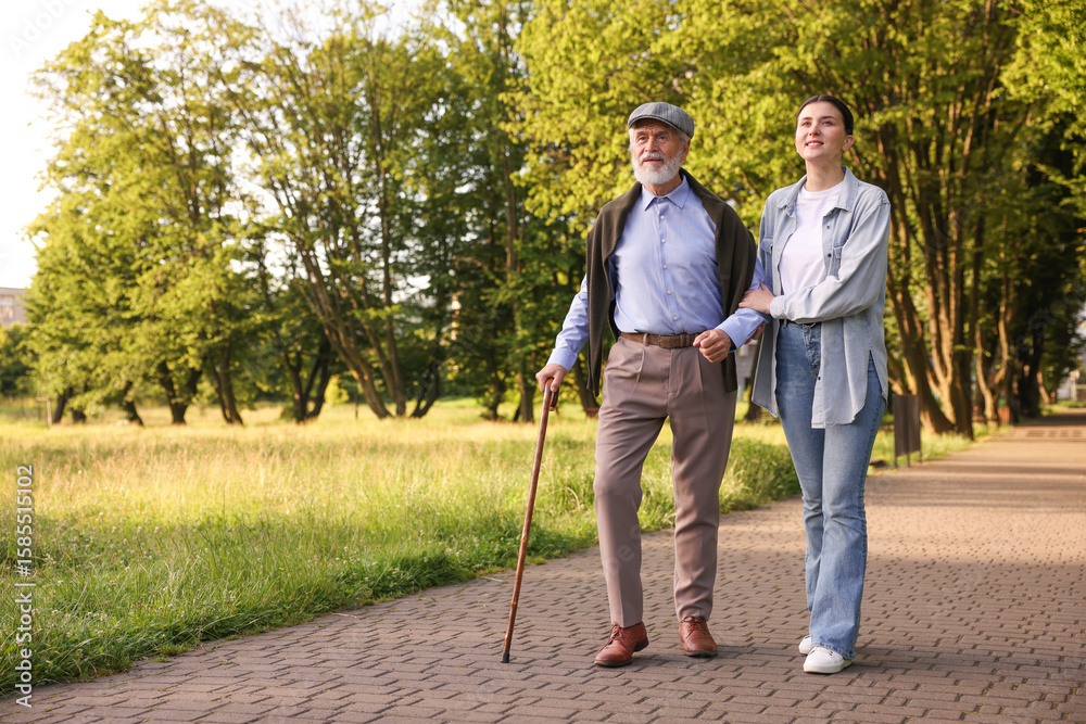 Φωτογραφία Smiling caregiver supporting elderly man with walking cane outdoors
