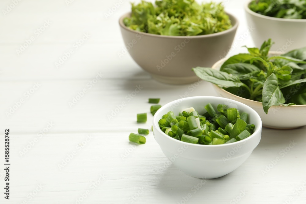 Different aromatic herbs in bowls on white wooden table, closeup. Space for text Different aromatic herbs in bowls on white wooden table, closeup. Space for text
