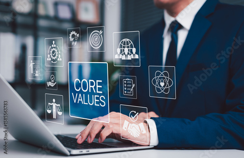 Business Core Values and Corporate Culture Concept. Businessman working on laptop with core values icons, ethics, teamwork, integrity, corporate mission, organizational culture and business principles