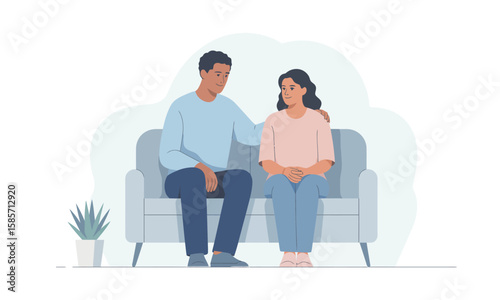 A man comforts a sad woman by placing his hand on her shoulder as they sit together on a sofa in a minimalist room.